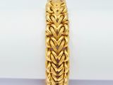 a close up of a gold bracelet on top of a napkin
