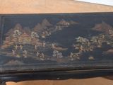 a black table with a painting on the top of it