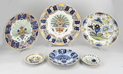 Plusieurs assiettes et bols sont posés sur une surface blanche.