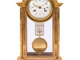 a gold clock with a pendulum on a white background