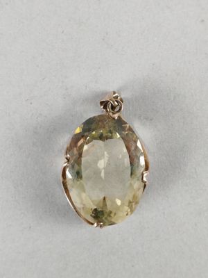 a close up of a pendant with a faceted yellow quartz stone