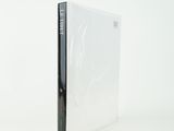 a white book sitting on top of a white table next to a white wall