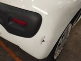 a white car with a black tail light on it