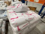 a large pile of white pillows on a pallet in a warehouse