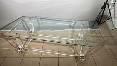 une table basse en verre posée sur un sol carrelé dans une pièce