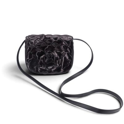Le petit sac noir est orné d'une fleur sur le devant.
