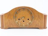 a wooden clock that is sitting on a white surface