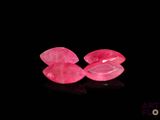a pair of pink sapphires on a black surface