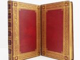 un livre rouge orné d'une bordure dorée