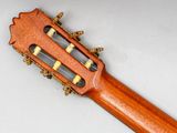 a close up of an acoustic guitar on a white surface