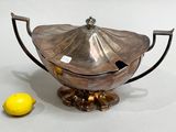 a silver teapot with a lemon next to it