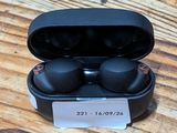 a close up of a pair of black earphones on a wooden table