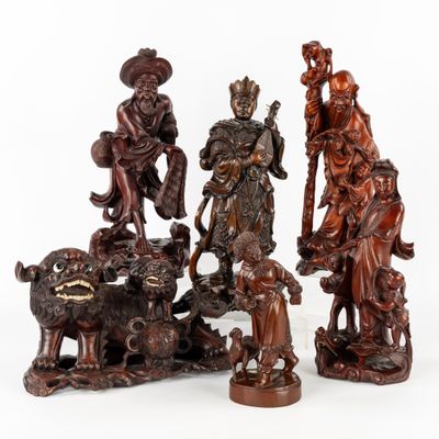 quatre figurines sculptées représentant des personnages et des animaux sur un fond blanc