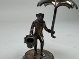 a statue of a man holding an umbrella and a watering can