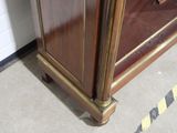 a wooden cabinet with a glass door in a room