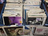 beaucoup de disques dans une caisse bleue posée par terre
