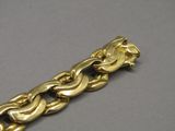 a close up of a gold bracelet on a gray surface