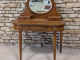 a small wooden vanity with a mirror on top of it