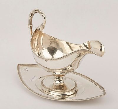 an image of a silver sauce boat on a sauce plate