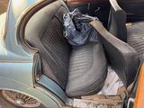 a blue car with a black seat and a blue bag in the back