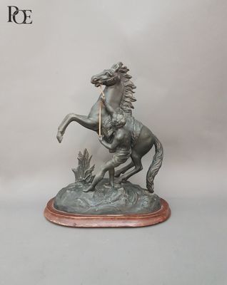 statue représentant un cheval avec un cavalier sur le dos, posée sur un socle en bois