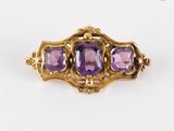 un gros plan d'une bague en or sertie de trois améthystes