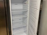 an open refrigerator in the corner of a kitchen