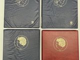 quatre livres aux couvertures dorées et noires posés sur une table