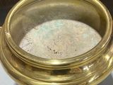 a gold bowl sitting on top of a white table