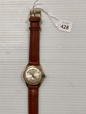 une photo d'une montre-bracelet posée sur une surface blanche, avec une étiquette de prix