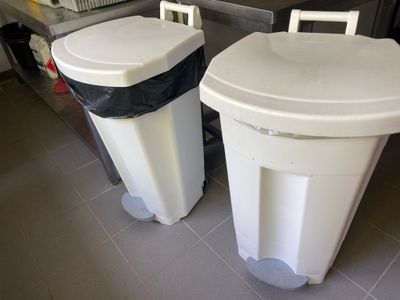 deux poubelles posées l'une à côté de l'autre sur le sol