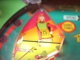 a close up of a pinball machine with a person on it