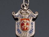 an image of a silver charm with a red and blue crest on it