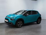 une voiture bleue garée dans un garage, près d'un mur blanc