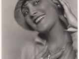 une vieille photo en noir et blanc d'une femme portant un chapeau et un collier de perles
