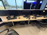 un bureau équipé de deux écrans et d'un clavier, placé devant une fenêtre