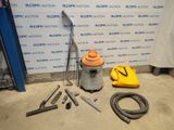 un aspirateur et d'autres outils posés par terre devant un mur