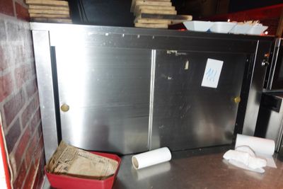 un comptoir en métal sur lequel sont posés un seau rouge et une poubelle rouge