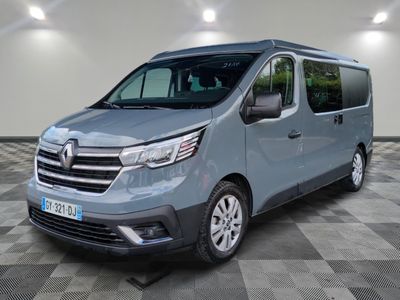 La camionnette grise est garée dans une grande pièce au sol carrelé en damier.