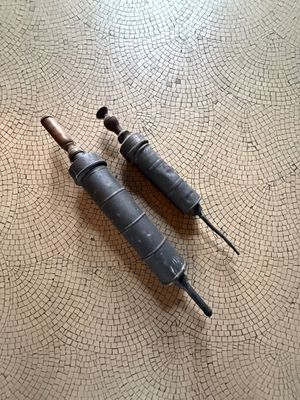 two screws that are sitting on a tile floor