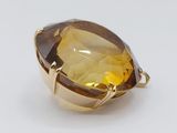 a close up of a yellow quartz pendant on a white surface