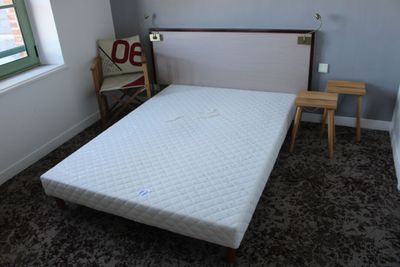 un lit avec un matelas dans une chambre dotée d'une fenêtre