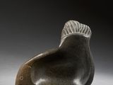 sculpture of a fish on a gray surface with a black background