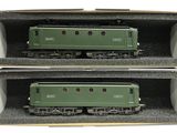 deux wagons verts dans une boîte posée sur une surface blanche