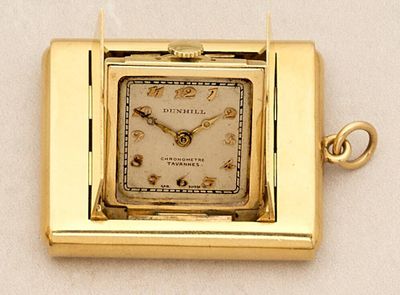 a small square gold watch with a chain around it