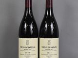 two bottles of wine sitting on top of a table next to each other