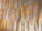 une carte du monde posée sur une table, avec une tasse de café à côté