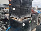 une pile de boîtes noires et une tondeuse à gazon verte