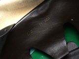 a close up of a pair of black shoes with a green sole