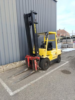 un chariot élévateur garé devant un bâtiment dans un parking